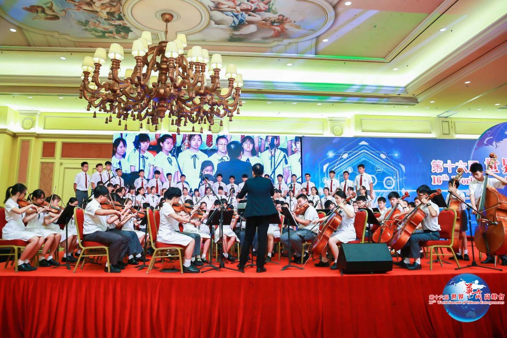 第十六屆世界華商高峰會開幕典禮-澳門培正中學管弦樂團及歌詠隊在開幕典禮上演唱《華商頌》。